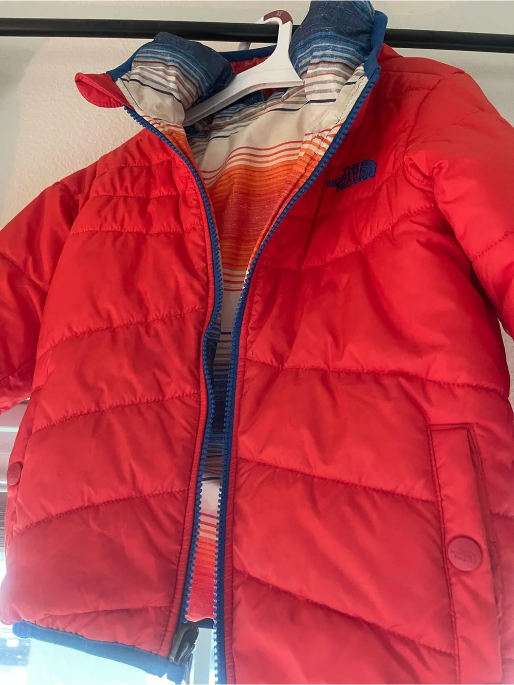 The North Face reversible Solid Red or Vibrant Striped side Puffer Jacket.